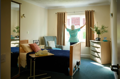 nurse opening curtains in a residents bedroom